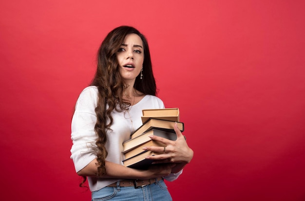 Mooie vrouw wordt moe van het dragen van boeken. Hoge kwaliteit foto