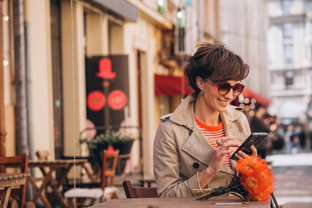 Mooie vrouw zit in café in China Town en praat aan de telefoon