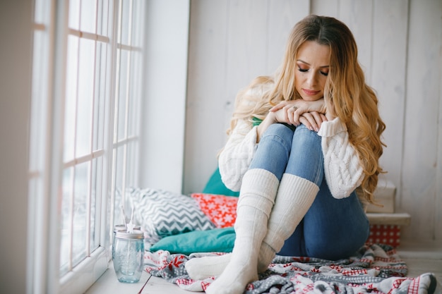 Mooie vrouw zit nog steeds op het raam