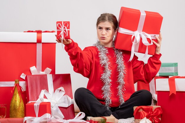 mooie vrouw zitten rond kerstcadeautjes op wit