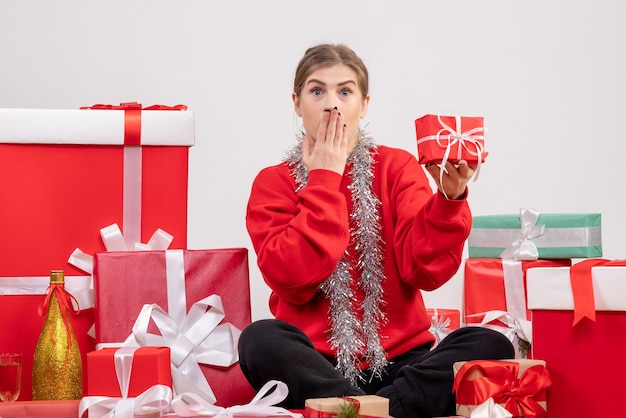 Mooie vrouw zitten rond kerstcadeautjes op wit