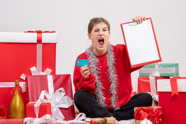 mooie vrouw zitten rond kerstcadeautjes op wit