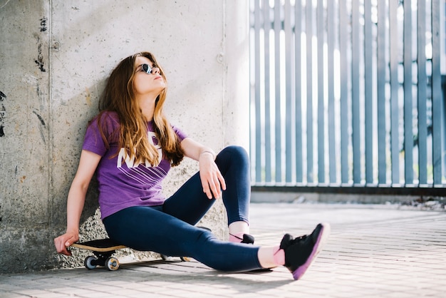 Mooie vrouw zittend op skateboard