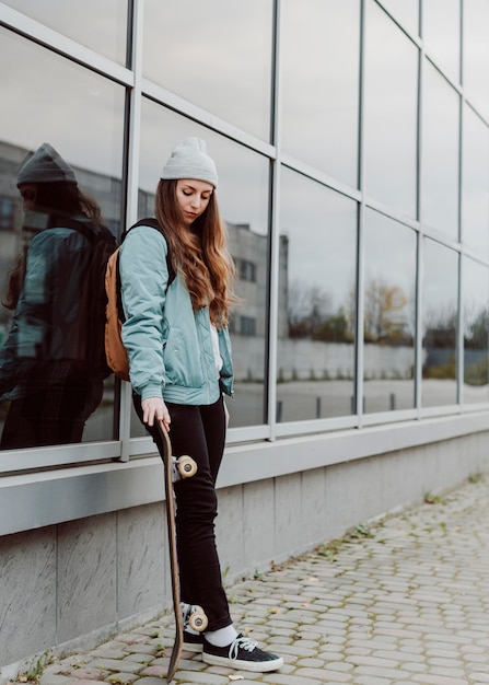 Mooie vrouwelijke skater met haar skateboard