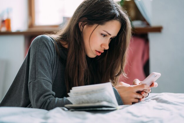 Mooie vrouwelijke student die voor aanstaand onderzoek voorbereidingen treft.