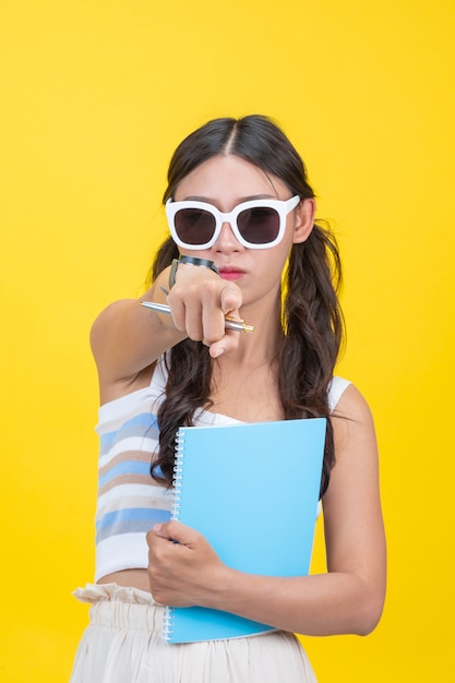 Mooie vrouwelijke studenten houden notitieboekjes en pennen