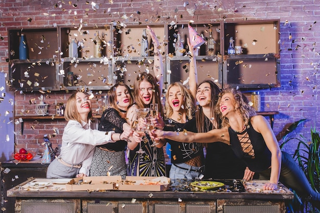 Mooie vrouwen klinkende glazen in confetti