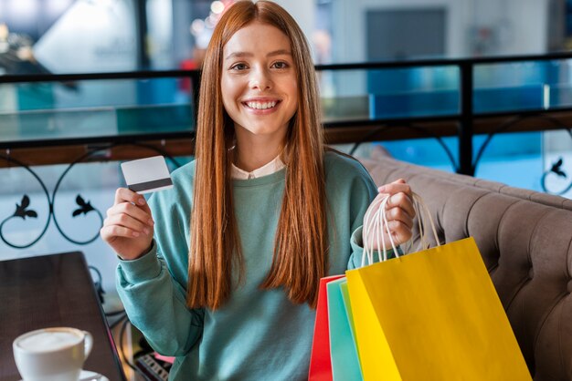 Mooie vrouwenholding het winkelen zakken en creditcard