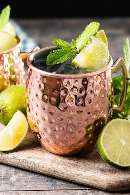 Gratis foto moscow mule cocktail served with ice and lime slice on wooden table