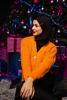 Moslimmeisje in zwarte hijab droomt over cadeau op nieuwjaarsvakantie. kerstviering van islamitische religie mensen.