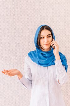Moslimvrouw die telefoongesprek maakt