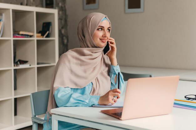 Moslimvrouw in hijab die in kantoorruimte werkt