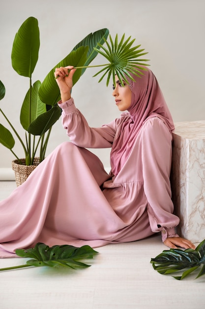 Gratis foto moslimvrouw met blad zijaanzicht