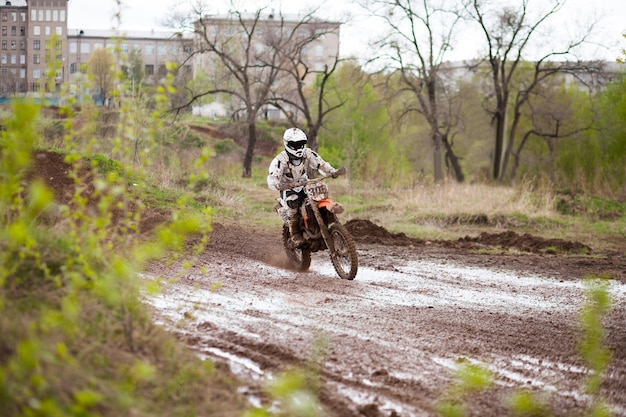 Motorcrosser beweegt op een modderpad