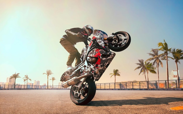 Motorrijder maakt een stunt op zijn motor biker doet een moeilijke en gevaarlijke stunt