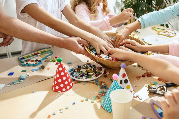 mozaïek puzzelkunst voor kinderen, creatief spel voor kinderen. handen spelen mozaïek aan tafel. Close-up van kleurrijke veelkleurige details.