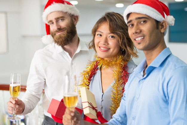 Multi-etnisch commercieel team dat Kerstmis Champagne drinkt