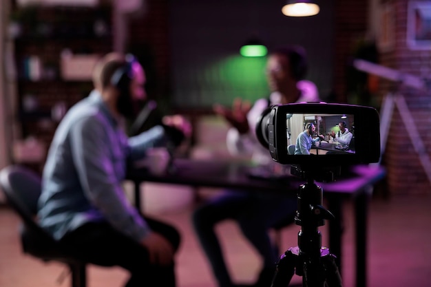 Gratis foto multi-etnisch team van mensen die bijeenkomen om internetpodcast uit te zenden en videodiscussie op camera op te nemen. influencer en gast praten op online livestream om content voor social media-kanalen te creëren.