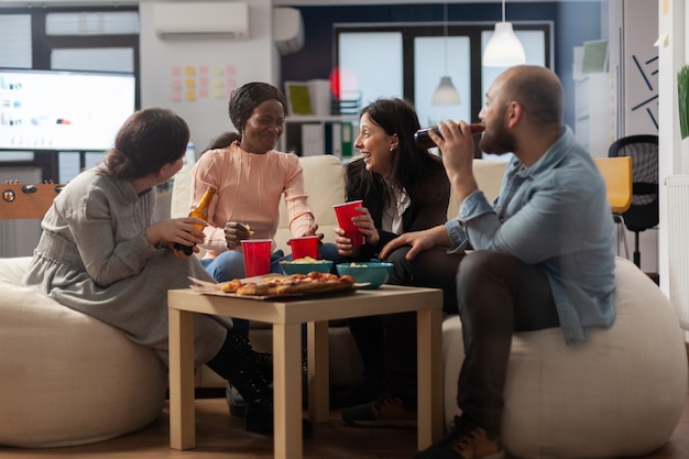 Multi-etnische collega's die plezier hebben na het werk op kantoor