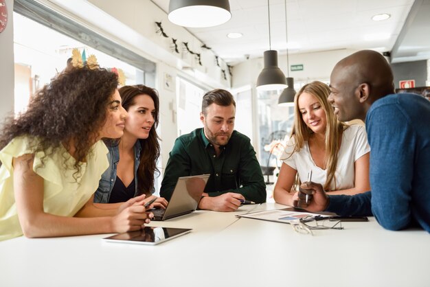 Multi-etnische groep jonge mensen die samen op wit deen studeren