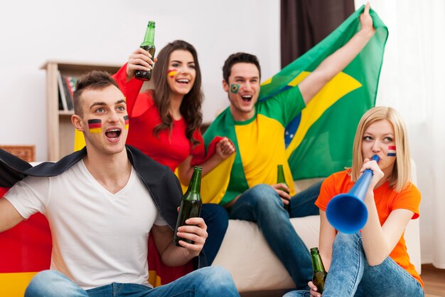 Multi-etnische groep mensen juichen voetbalwedstrijd