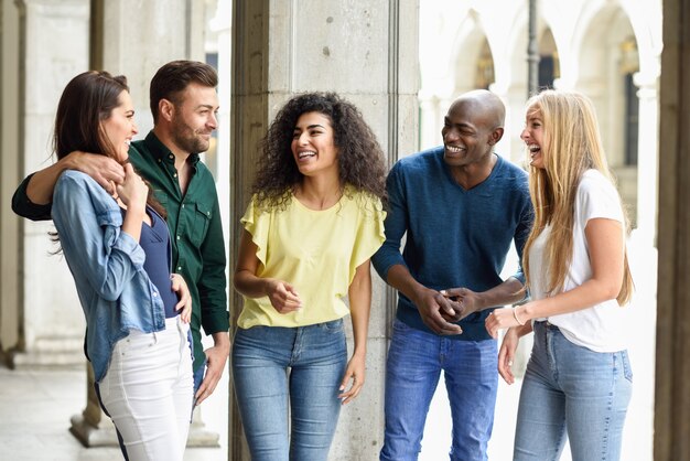 Multi-etnische groep vrienden die plezier samen hebben in stedelijke backg