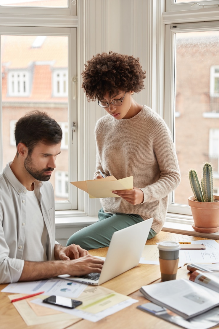 Gratis Foto multi-etnische ontwerpers poseren tegen raam
