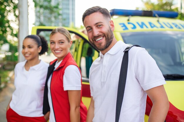 Multi-etnische paramedici staan voor de ambulance Noodarts en verpleegkundige staan voor de ambulance