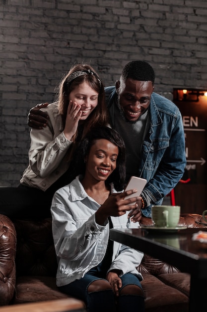 Multiculturele vrienden kijken naar telefoon