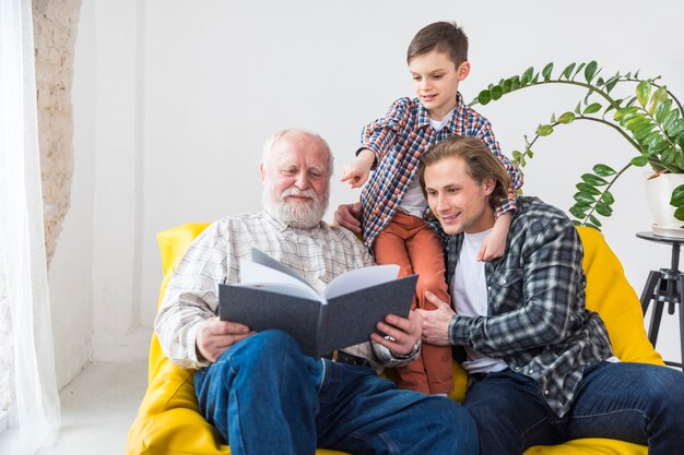 Multigenerationele mannen die naar een album kijken