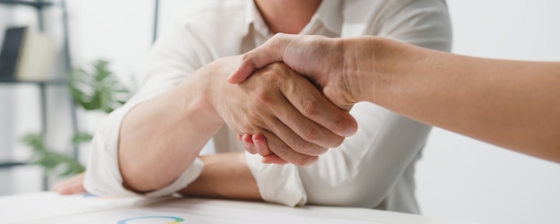 Gratis foto multiraciale groep jonge creatieve mensen in slimme vrijetijdskleding die zaken bespreken die samen handen schudden