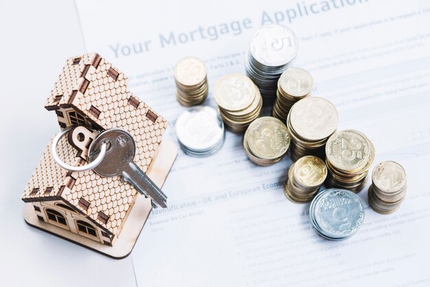 Munten en sleutel op blad van hypotheekaanvraag