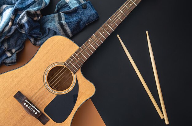 Muziekachtergrond met bovenaanzicht van gitaar en drumsticks