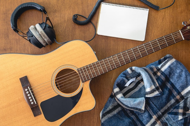 Muziekachtergrond met gitaarkoptelefoons en notitieblok bovenaanzicht