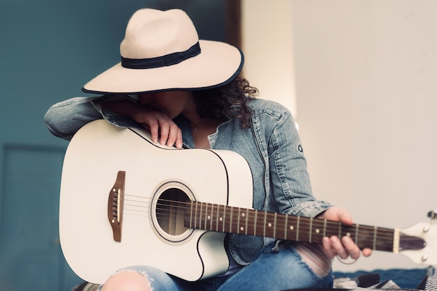 Gratis foto muzikant met hoed en gitaar