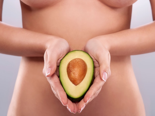 Naakte vrouw met de verse avocado