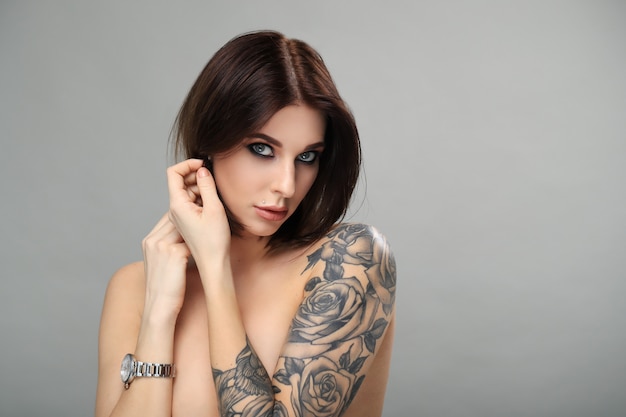 Naakte vrouw met tatoeage poseren