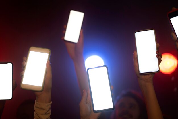 Nachtleven van mensen die dansen in een club en smartphones omhoog houden