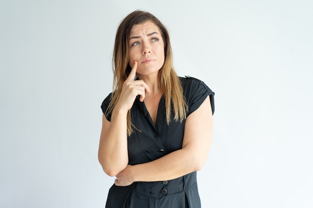 Nadenkend bezorgd jonge vrouw verloren in gedachten en wegkijken.