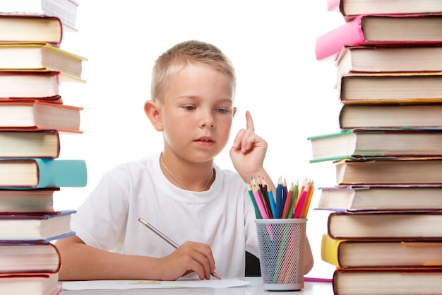 Nadenkend elementaire estudent met een potlood in de bibliotheek