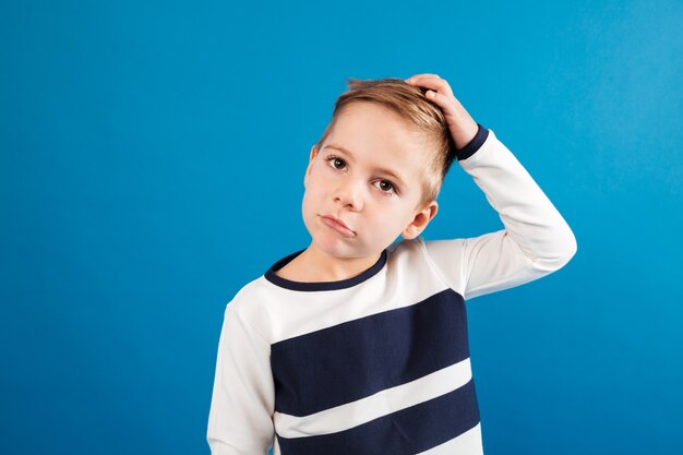 Nadenkend jonge jongen in de trui zijn hoofd aan te raken