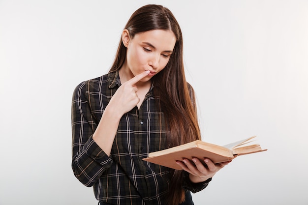 Gratis foto nadenkend vrouw in shirt leesboek