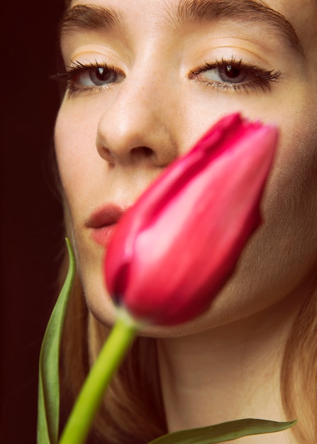 Gratis foto nadenkende jonge vrouw met heldere tulp