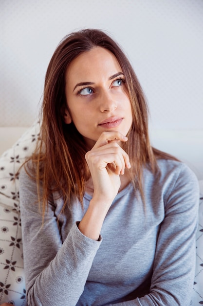 Nadenkende vrouw in bed