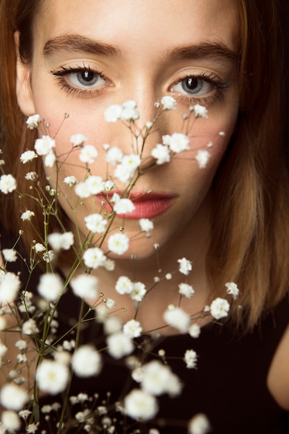 Gratis foto nadenkende vrouw met witte bloemen