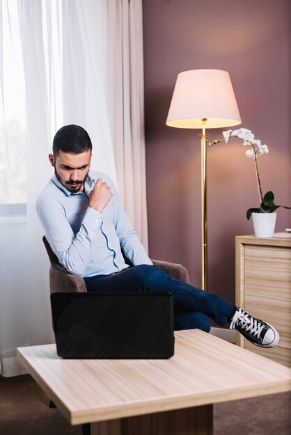 Nadenkende werknemer op laptop