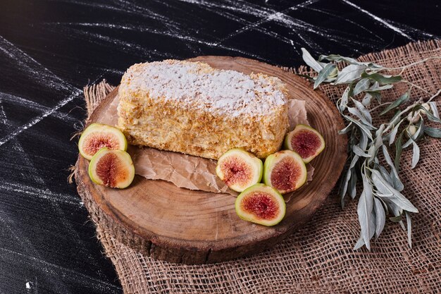 Napoelon cake met vijgen en bladeren op wollen tafelkleed.