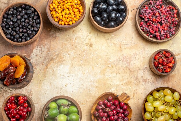 Gratis foto natuurlijk en vers divers fruit in bruine houten potten