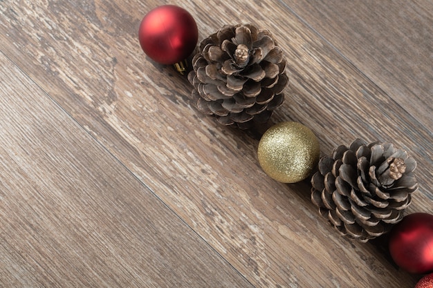 Natuurlijke eikenboomkegels op een houten terras met glinsterende ornamenten eromheen