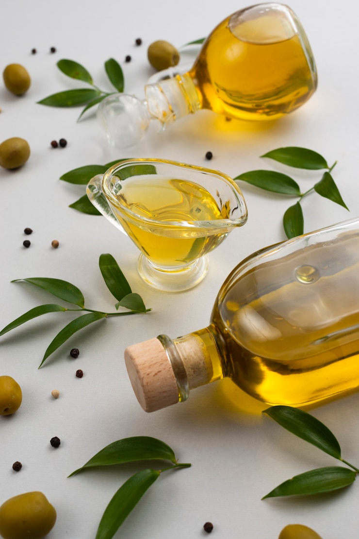 Gratis Foto natuurlijke olijfolie op fles en kop op tafel
